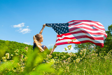 Woman holding American flag outdoors. United States flag, 4th of July