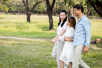 Fototapeta premium Parents and children walking hand in hand in the park.