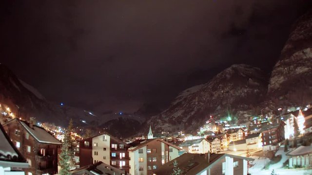 Night time timelpase of Zermatt with clouds blowing over the Matterhorn in the distance