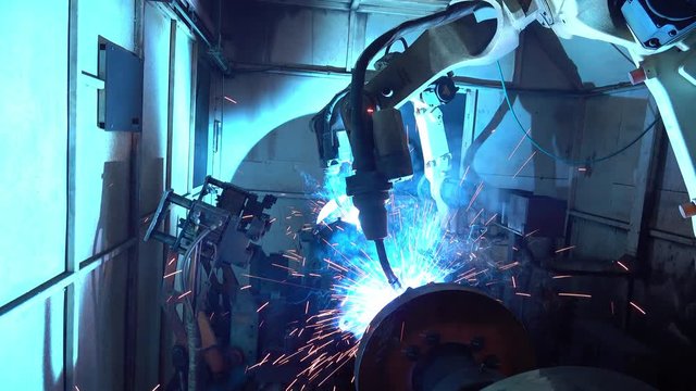 Team industrial robot are movement welding automotive part in factory