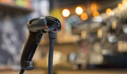 Close up barcode scanner in hand on blurred background,Inspection of goods in the warehouse,The concept of selling products in a supermarket,Spot focus,Copy space.