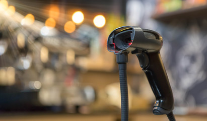 Close up barcode scanner in hand on blurred background,Inspection of goods in the warehouse,The concept of selling products in a supermarket,Spot focus,Copy space.