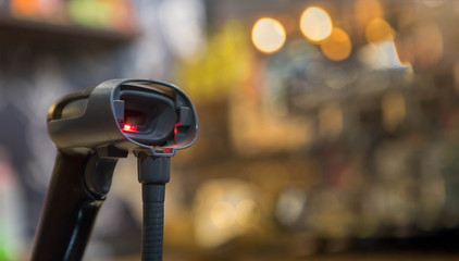 Close up barcode scanner in hand on blurred background,Inspection of goods in the warehouse,The concept of selling products in a supermarket,Spot focus,Copy space.