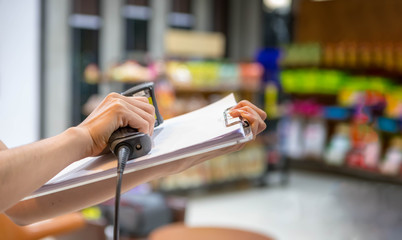 Close up barcode scanner in hand on blurred background,Inspection of goods in the warehouse,The concept of selling products in a supermarket,Spot focus,Copy space.