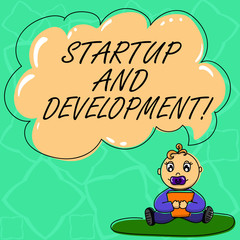 Word writing text Startup And Development. Business concept for search for a repeatable and scalable business model Baby Sitting on Rug with Pacifier Book and Blank Color Cloud Speech Bubble