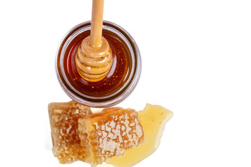 Honey dipper and full honey pot on a white background