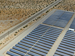 Aerial view of Genuine Energy Farm in the Hot Arid Desert of Palm Springs California features Solar Panels and wind turbines to Harness the Power of Nature to generate free green energy.