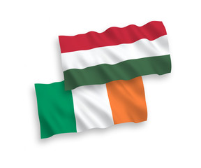 National vector fabric wave flags of Ireland and Hungary isolated on white background. 1 to 2 proportion.
