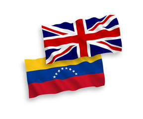 National vector fabric wave flags of Great Britain and Venezuela isolated on white background. 1 to 2 proportion.