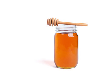 glass jar full of honey with a wooden dipper on top