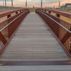 Frame Square Close up of a bridge with a wooden deck and brown metal guardrails