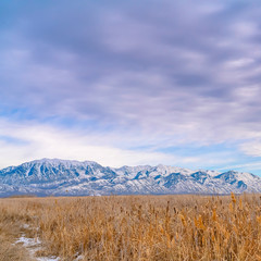 Frame Square Panorama of a vast valley and distant snowy mountain under striking cloudy sky