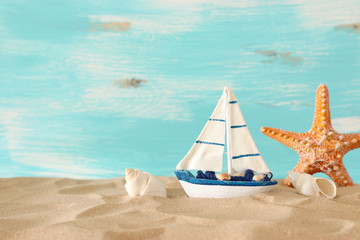 Fototapeta na wymiar vintage wooden boat over beach sand and pastel blue background