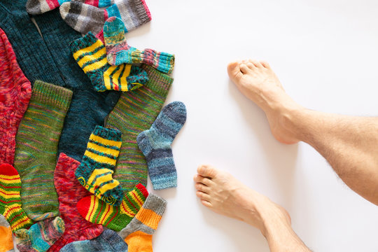 Colorful woolen socks and a pair of legs on white background