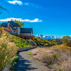 Square Trail along houses in front of a lake with grassy shore viewed on a sunny day