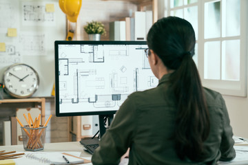 Back view portrait of asian woman engineer working on desktop computer with blueprints on screen in office. young female architect worker sitting in studio looking at pc screen interior design plan - Powered by Adobe