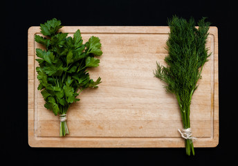 Fresh vegetables on cutting board. Parsley and dill