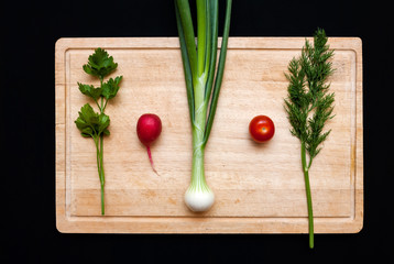 Fresh vegetables on cutting board.  Parsley, radish, dill, garlic, tomatoes