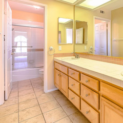 Frame Square Double vanity unit with wood cabinets inside the small bathroom of a house
