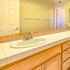 Frame Square Double vanity unit with wood cabinets inside the small bathroom of a house
