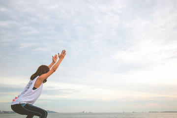 Woman is exercising yoga on blue sky.
