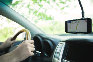 The driver uses a mobile smartphone with a GPS map navigation application.
