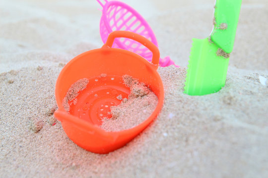 Baby toys on the beach sand against the blue sea and sky