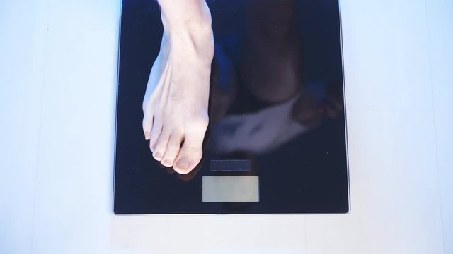 Person measure his weight with weighing scale 4K