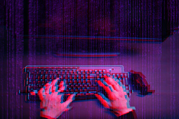 Hacker working with computer in dark room with digital interface around. Image with glitch effect.