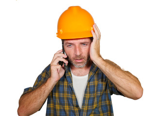 portrait of upset construction worker or stressed contractor man in builder hat talking on mobile phone unhappy in stress messing with work problem or mistake