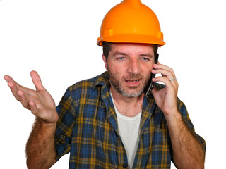 portrait of upset construction worker or stressed contractor man in builder hat talking on mobile...