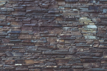 Gray and brown dilapidated stone texture of facade building. Rough brickwork, dirty weathered, grey dilapidated wall background. Grunge stone surface. Vintage floor. Abstract rock pattern for design. 