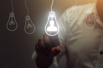 Businessman touching light bulbs. ideas of new ideas with innovative technology and creativity.