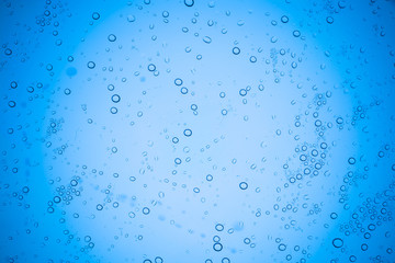 Rain droplets on blue glass background, Water drops on glass.