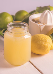 Delicious jar of Lemon juice lemonade on a wooden table.