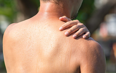 Fototapeta premium The hand grips the shoulder that inflammation from a sports injury.