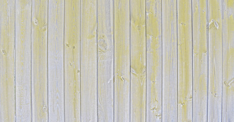 Natural wooden background. Surface of wooden texture for design and decoration. Shabby vertical boards with peeling paint. Gray and yellow color. Copy space.