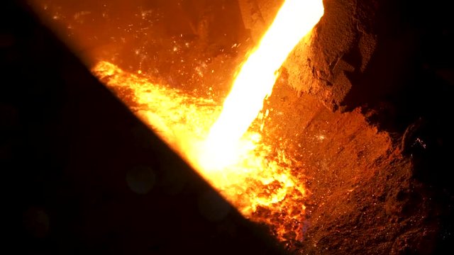 Molten steel being transferred from furnace to ladle in steel plant for further processing. Stock footage. Details of steel smelting at the metallurgical plant.