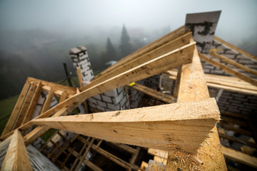 Top view of roof frame from wooden lumber beams and planks on walls made of hollow foam insulation blocks. Building, roofing, construction and renovation concept.