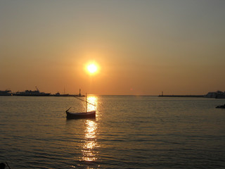Naklejka na ściany i meble small boat on the sunset