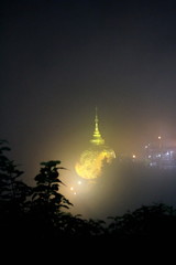 Night view of kyaiktiyo pagoda or Golden Rock with fog background are pagoda is famous tourist attraction in Mon state, Myanmar.