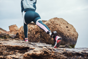 Go ahead Cropped image of disabled athlete woman in sportswear with prosthetic leg warming up on...