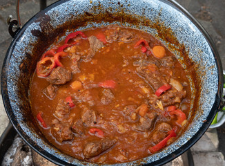 Ready kettle goulash after four hours cooking time over an open wood fire. With tomatoes, beef, onions, garlic, celeriac and carrots, food