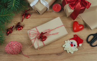 Christmas holiday Decoration; Christmas gift, fir tree branches and handmade toy santa claus on wooden background. Flat lay, top view