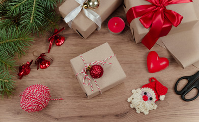 Christmas holiday Decoration; Christmas gift, fir tree branches and handmade toy santa claus on wooden background. Flat lay, top view