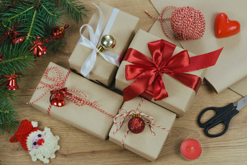 Christmas holiday Decoration; Christmas gift, fir tree branches and handmade toy santa claus on wooden background. Flat lay, top view