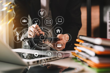 Businessman using mobile phone and laptop computer on white desk big data analytics with business intelligence concept. with VR chart and graph with icon