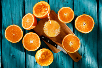 Fresh orange juice on blue wooden board and fresh fruits 