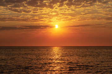 beautiful red sunset, dark clouds and ocean on the horizon