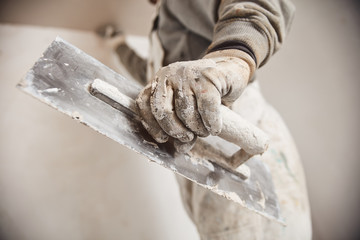 Workman plastering gypsum walls inside the house. - obrazy, fototapety, plakaty